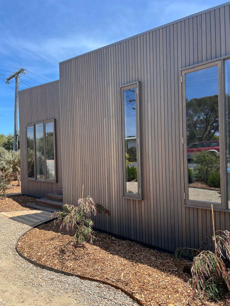 Dark weathered timber cladding with vertical windows